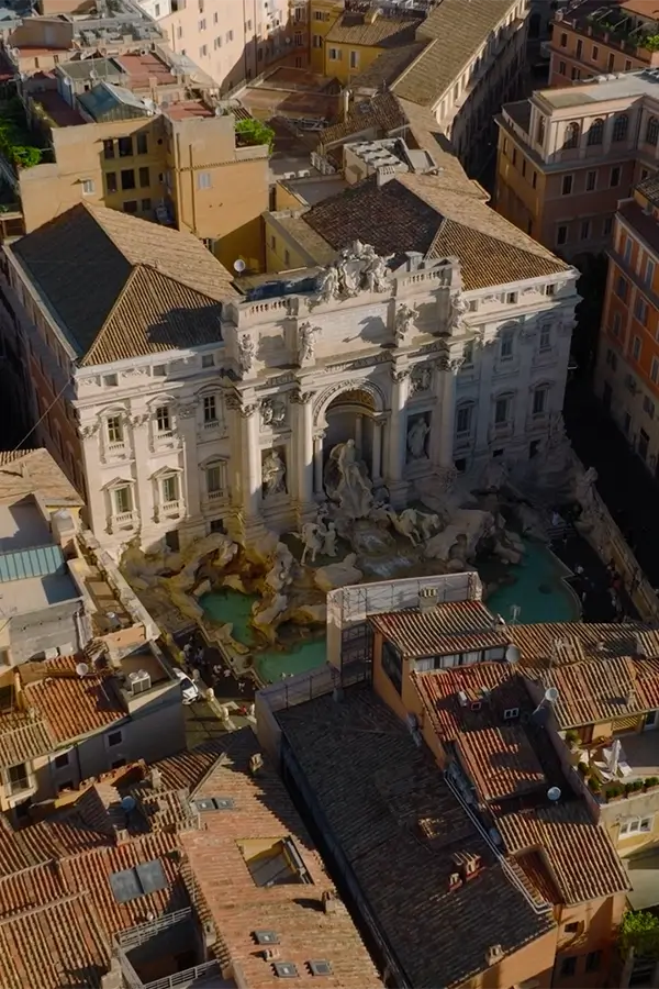 Aerial view of the Trevi Fountain surrounded by historic buildings in Rome, Italy.