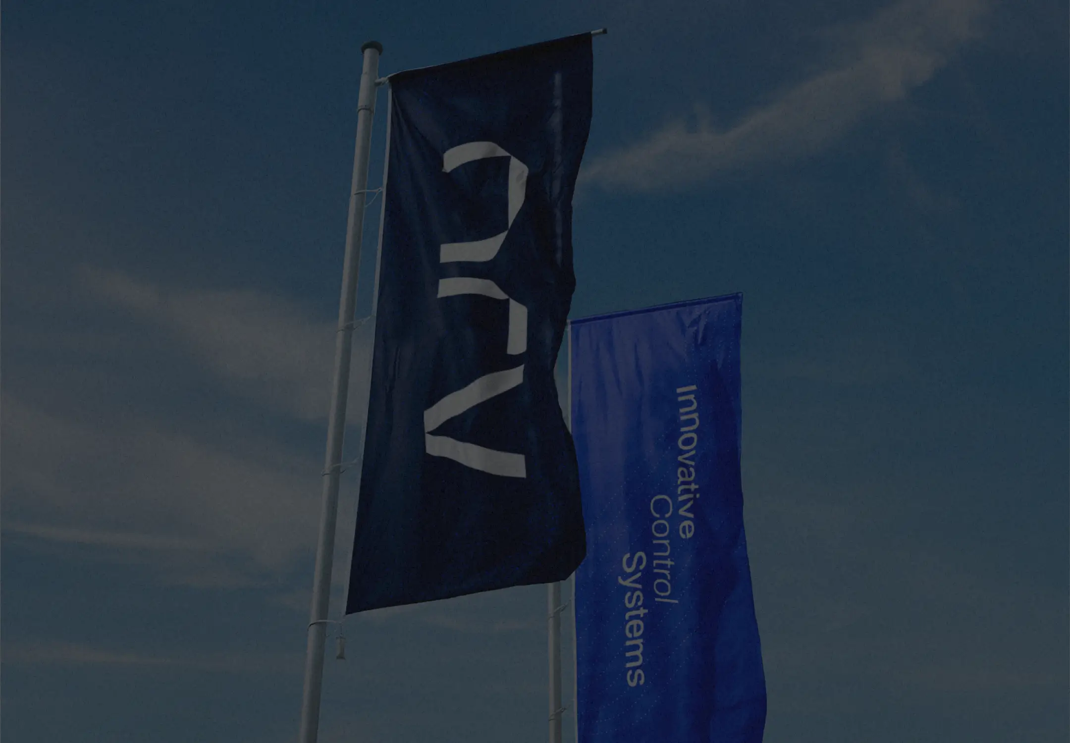 Outdoor corporate branding application with printed vertical fabric banners displaying the industrial identity and premium design standards chosen for the expansion.