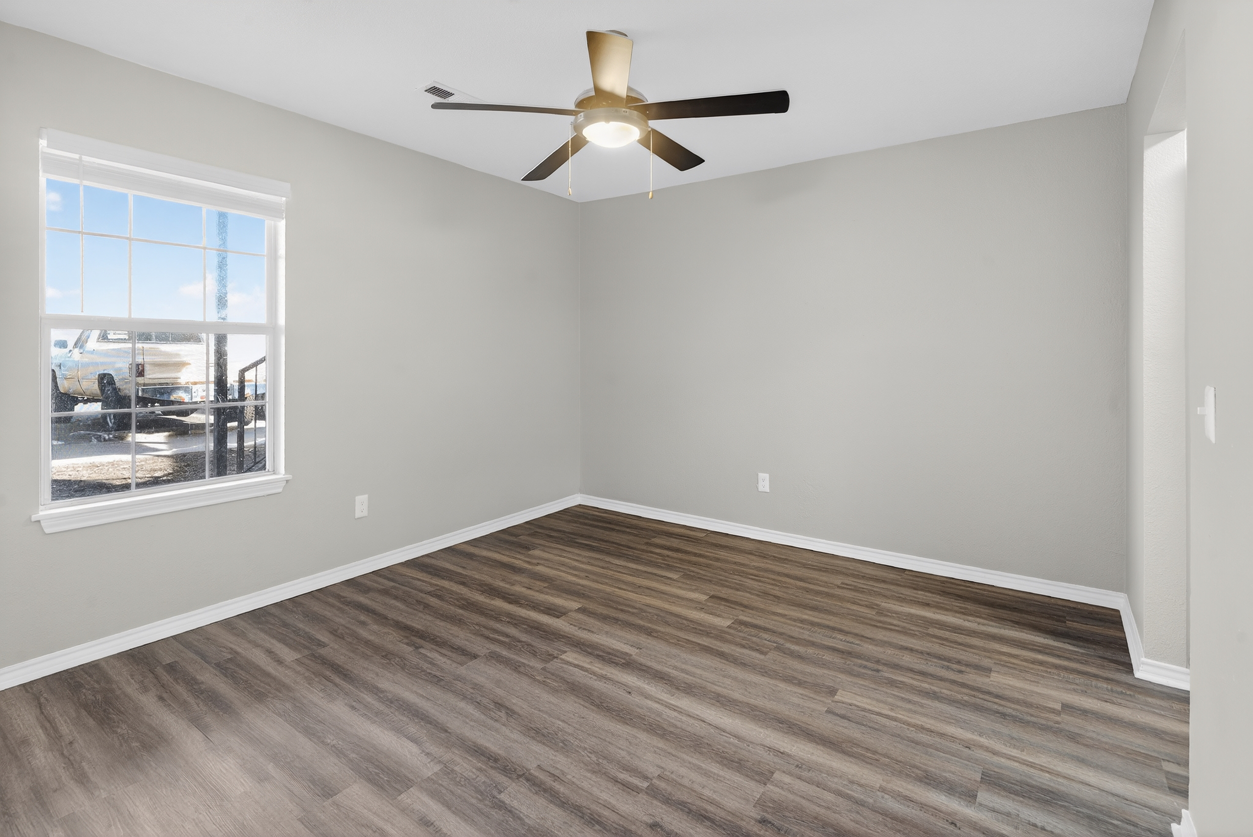 Unfurnished bedroom with ceiling fan and window