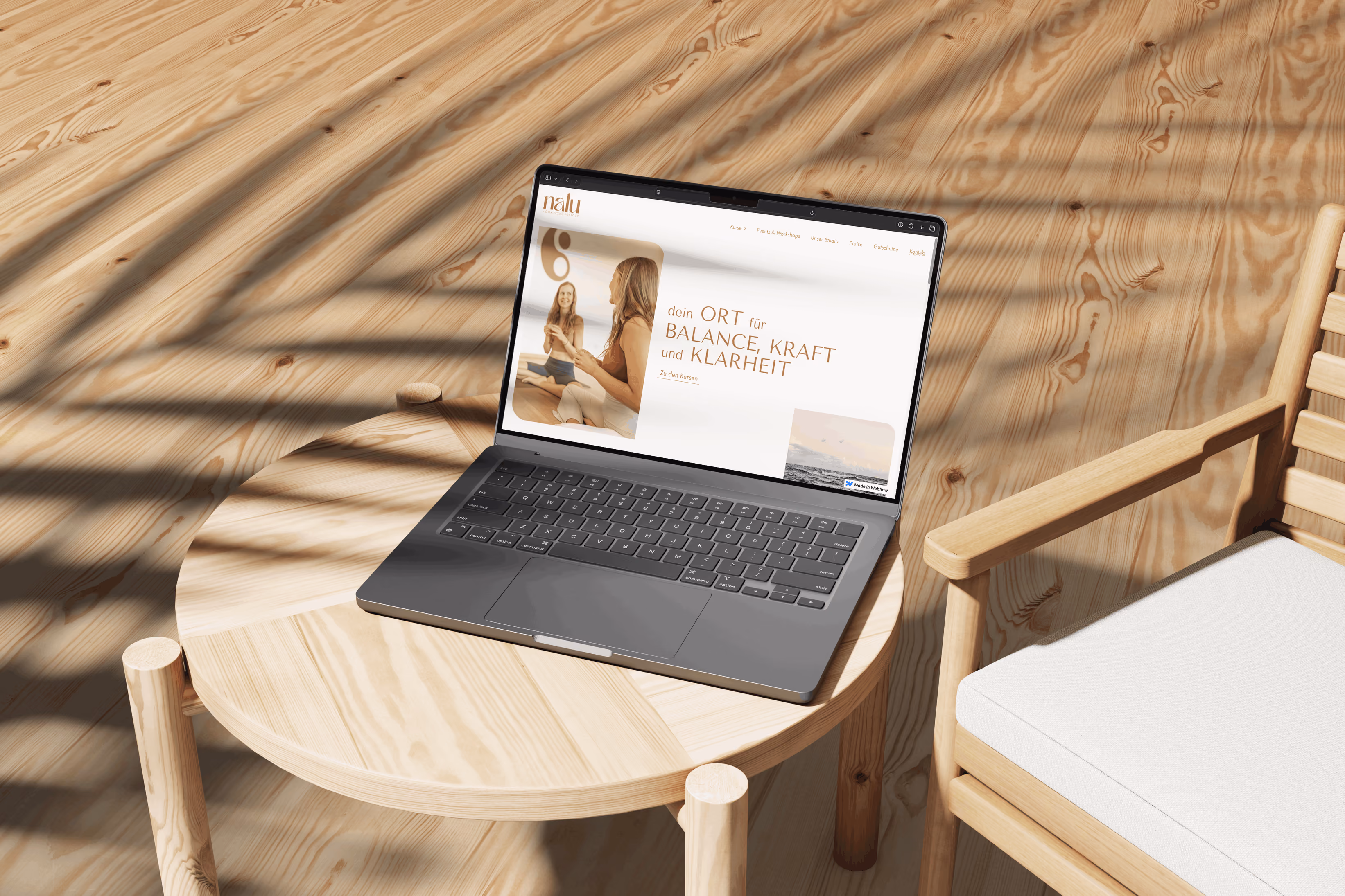 Website von Nalu Yoga Rostock auf einem Laptop auf einem runden Holztisch im Sonnenlicht
