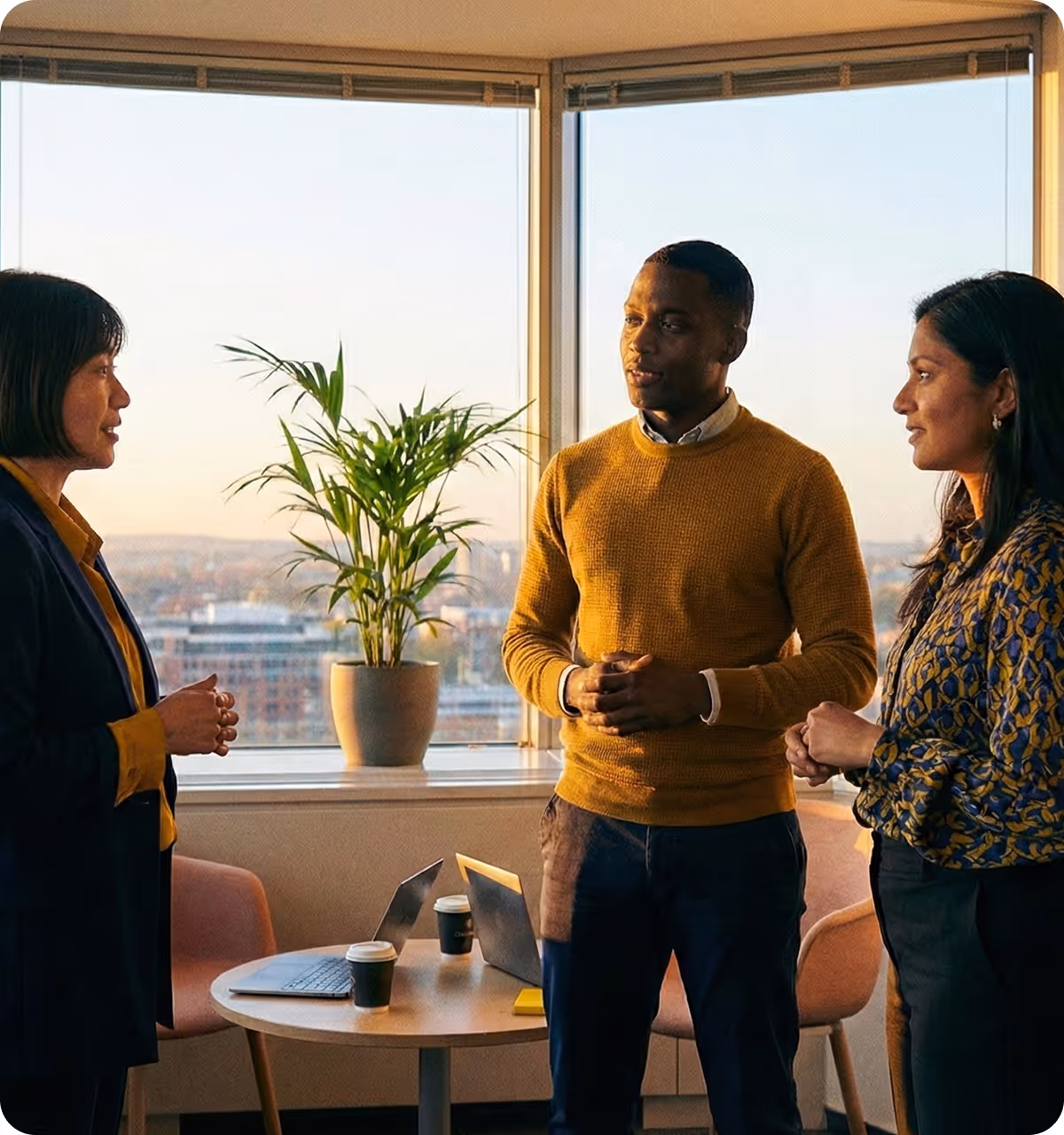 Three colleagues discussing work while standing