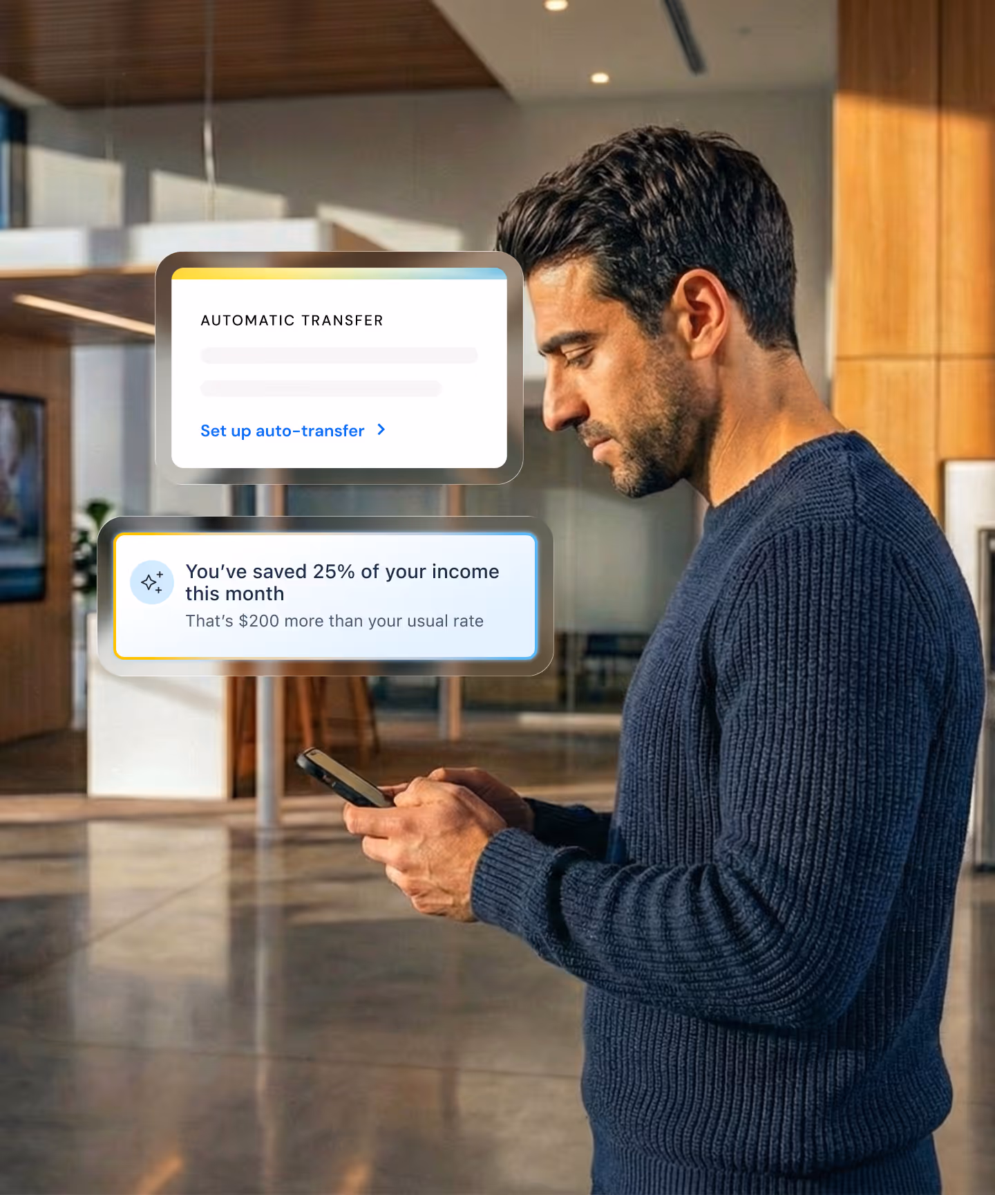 A man standing in an office checking his phone