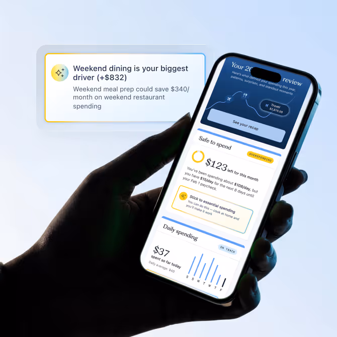 A hand holding a phone that's showing the Candescent app dashboard