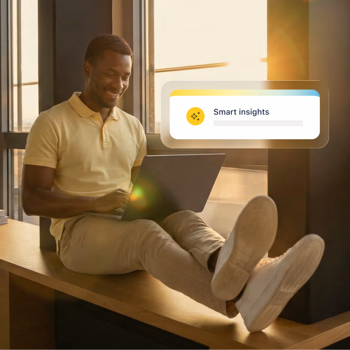 A man using his laptop while sitting over a ledge