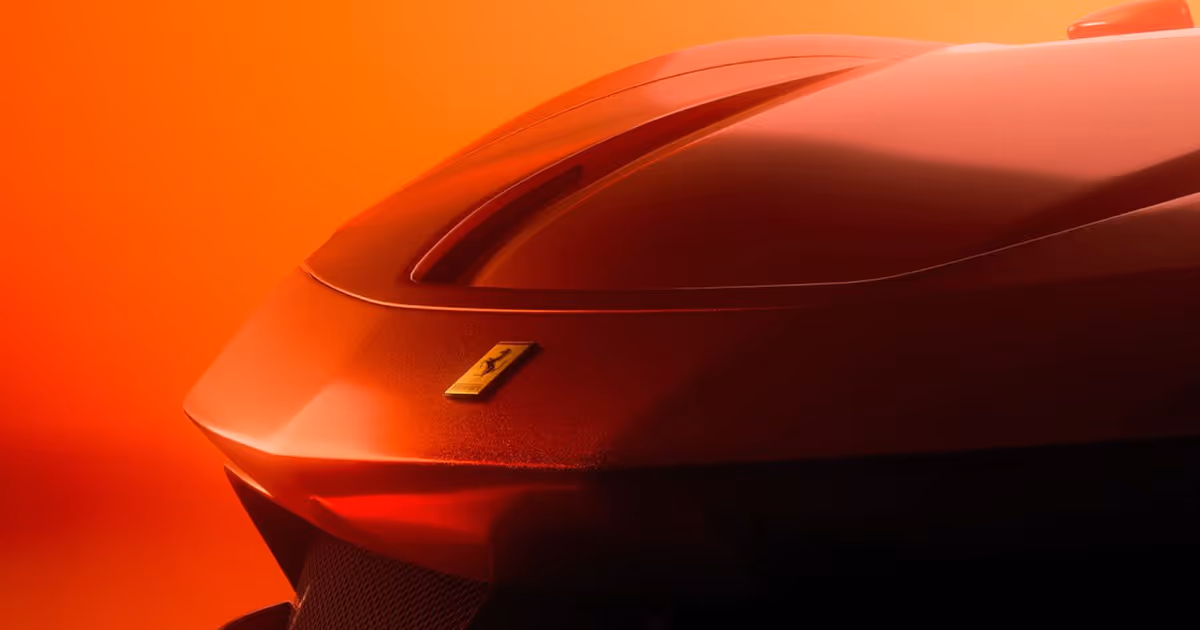 Close-up of the rear end of a red Ferrari sports car with an orange background.