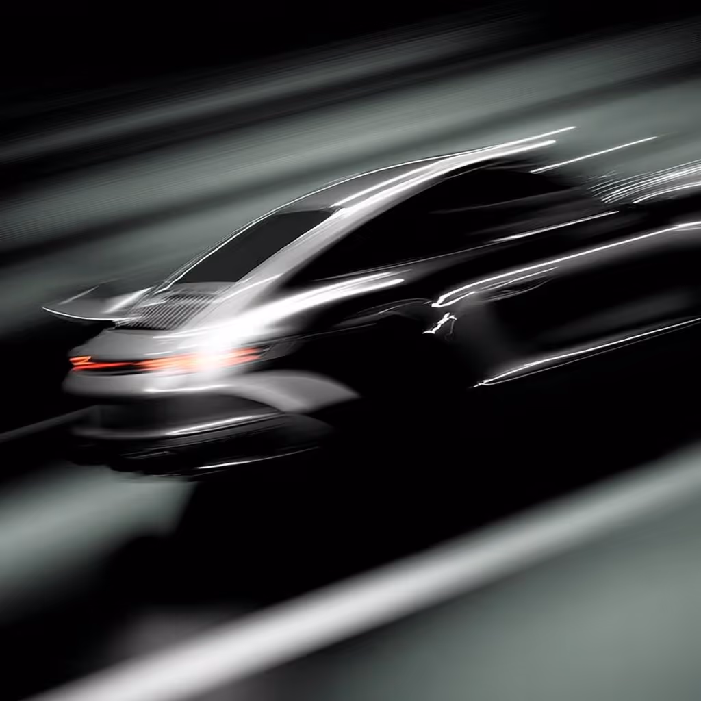 Silver sports car speeding on a road at night with motion blur effects.