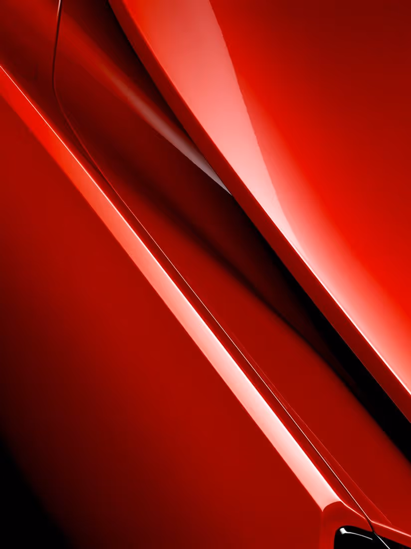 Close-up of the sleek, glossy red surface and sharp lines of a modern car body.