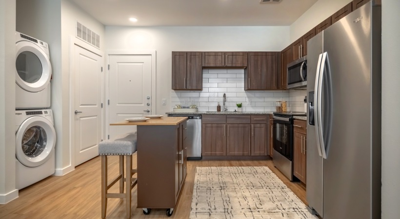 Kitchen with brown cabinets and in unit laundry