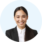 Smiling professional woman with long dark hair in a black blazer and white shirt against a light blue background.