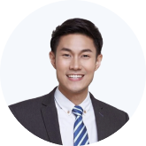 Smiling young man with short dark hair wearing a dark suit, white shirt, and striped tie.