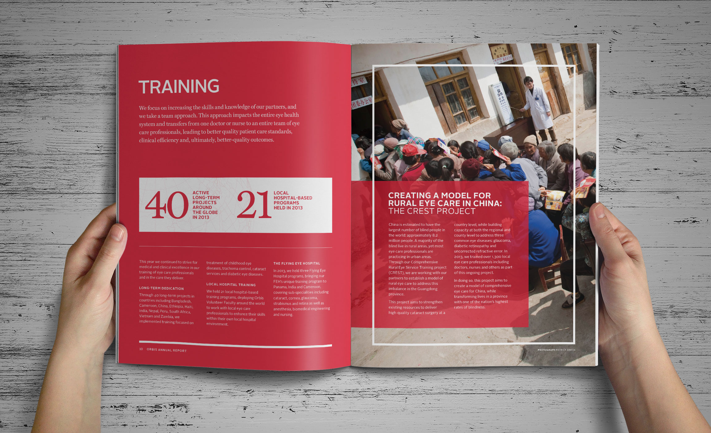 Hands holding Orbis Annual Report inside spread