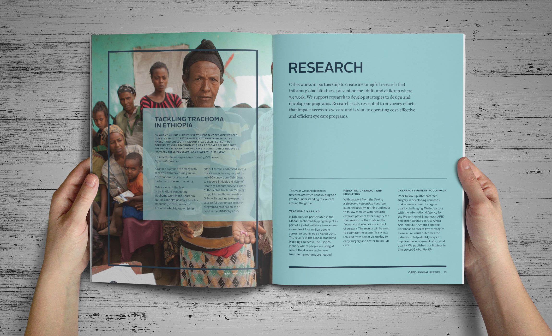 Hands holding Orbis Annual Report inside spread