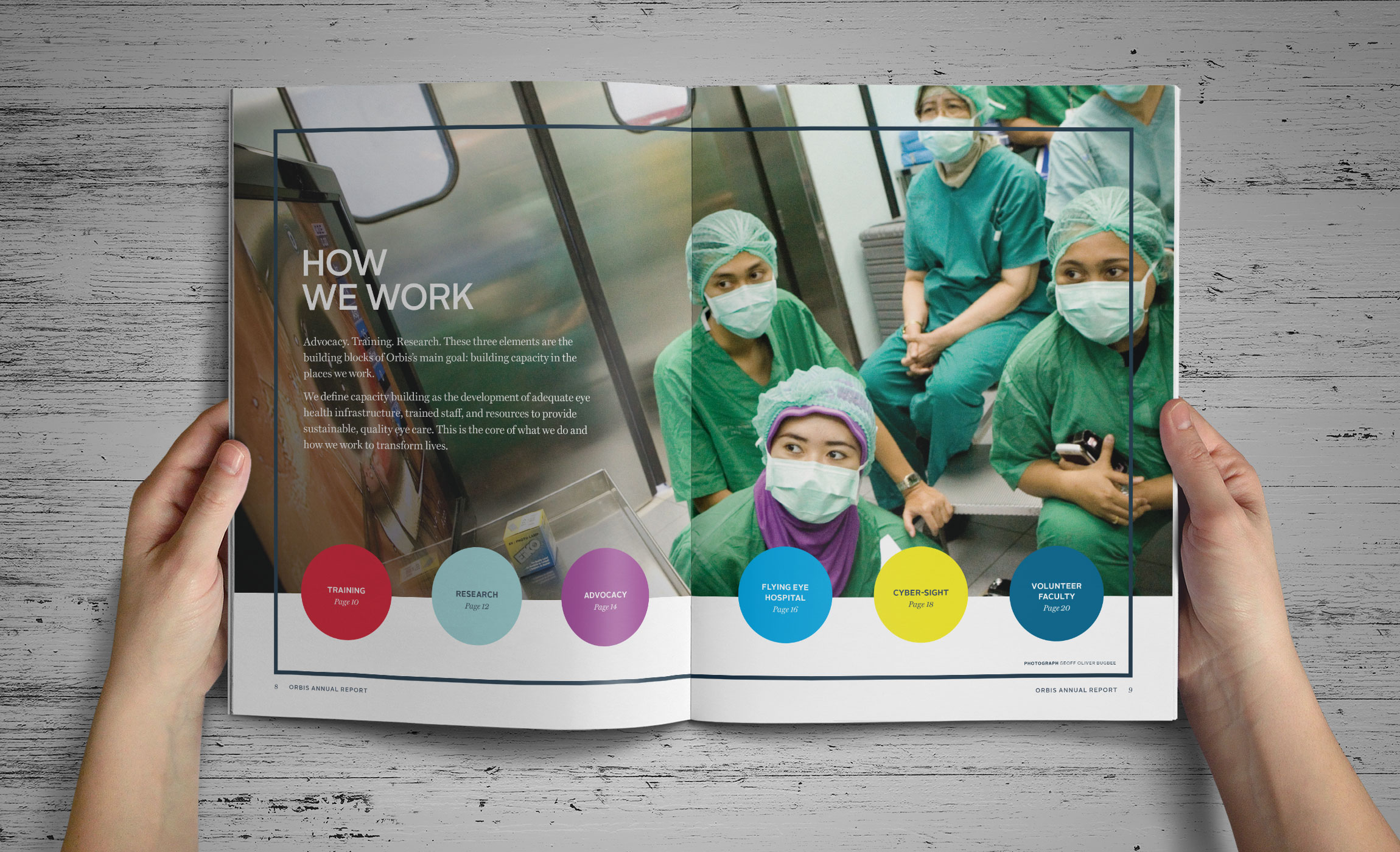 Hands holding Orbis Annual Report inside spread