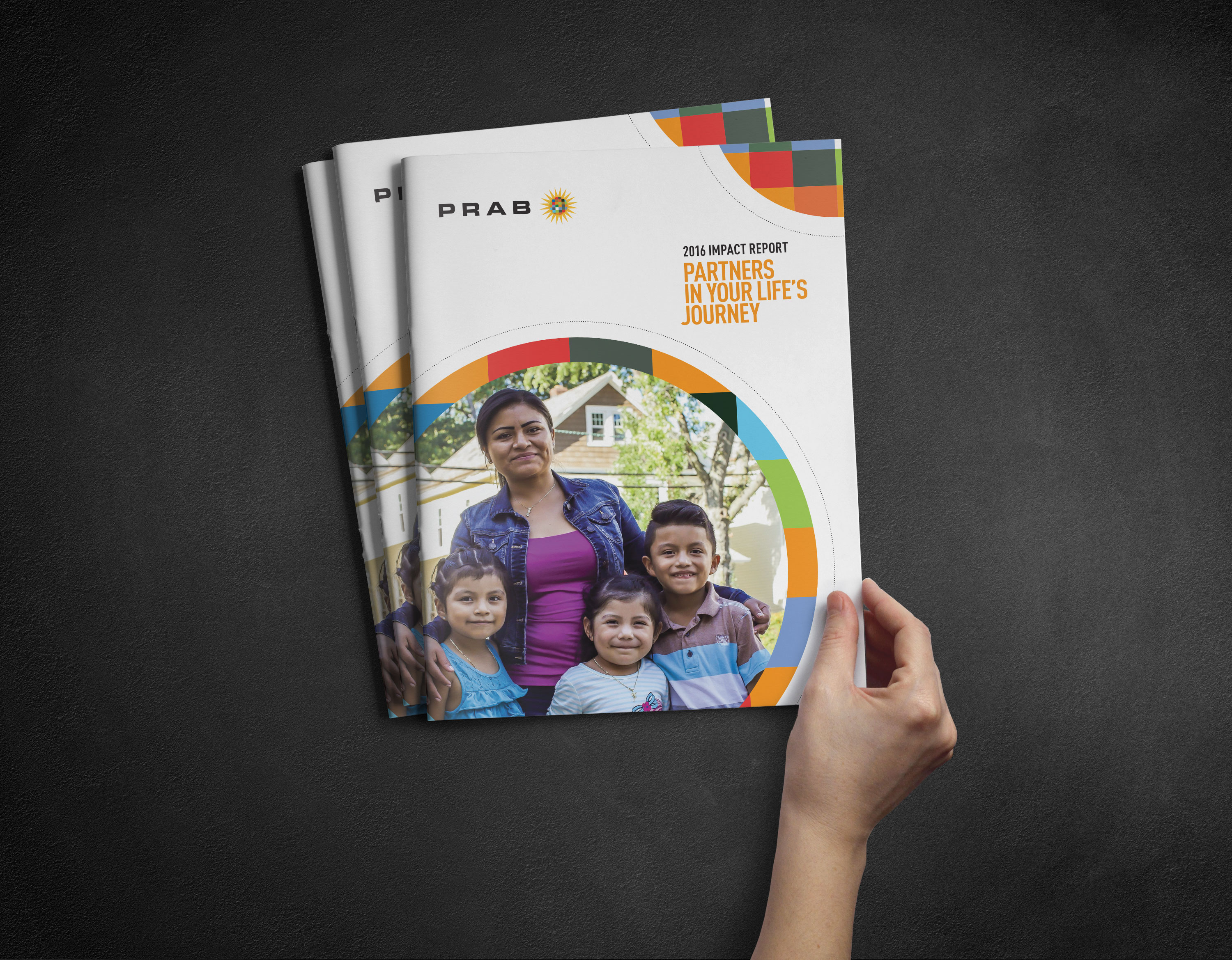 Hand holding PRAB Impact Report publications