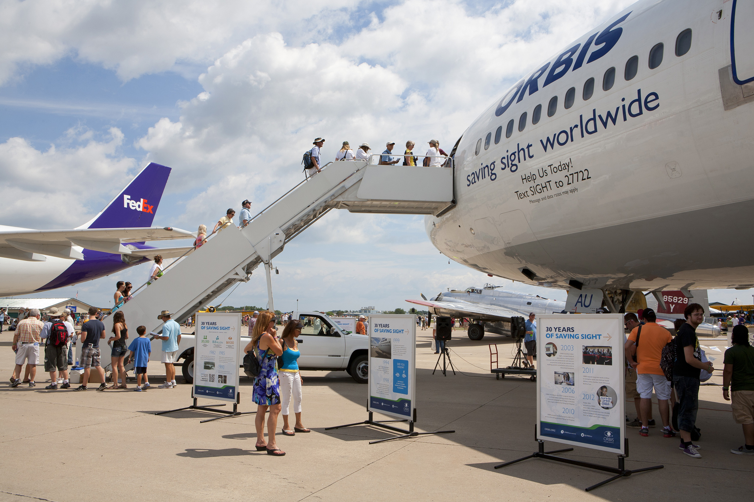 two exhibition attendees viewing Orbis exhibit stands