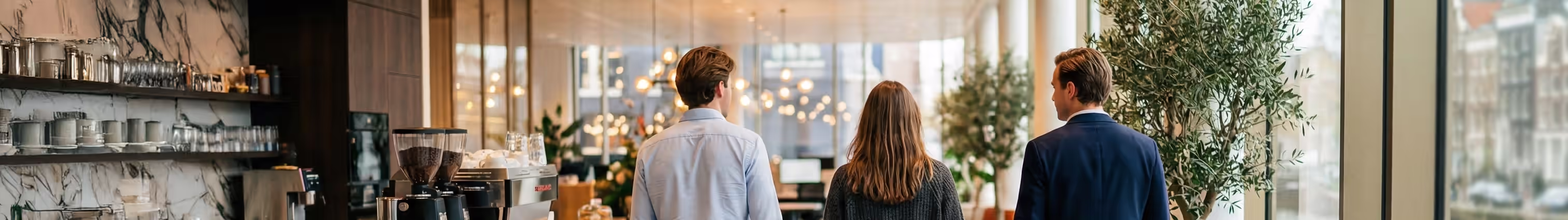 Four business professionals engaged in a meeting around a white conference table with laptops and documents.