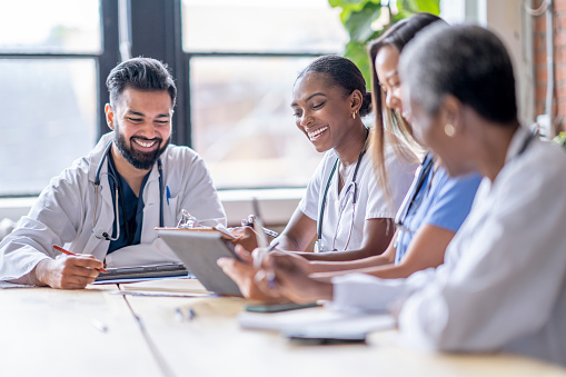 Medical professionals collaborating in a healthcare meeting while reviewing patient or research documents.