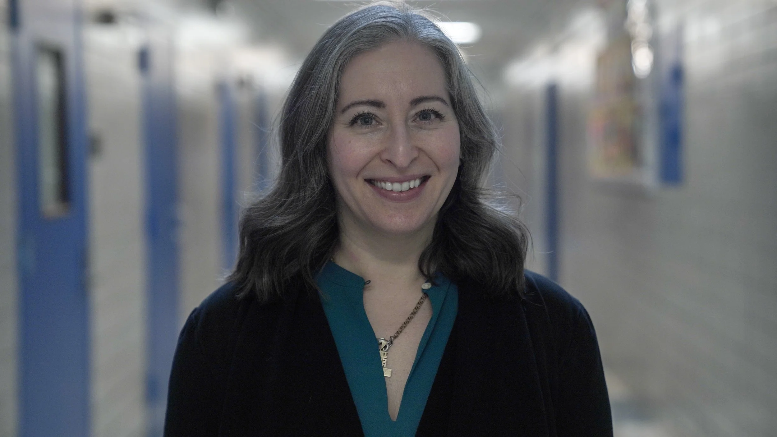 Lisa Pilaski smiling in a school hallway