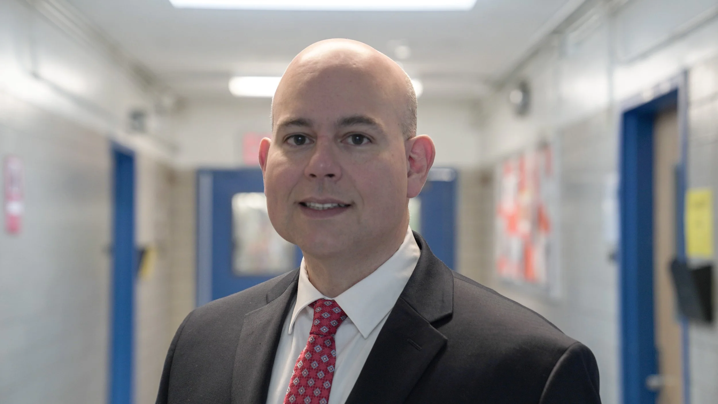 Principal Antonio Arocho standing in a school hallway