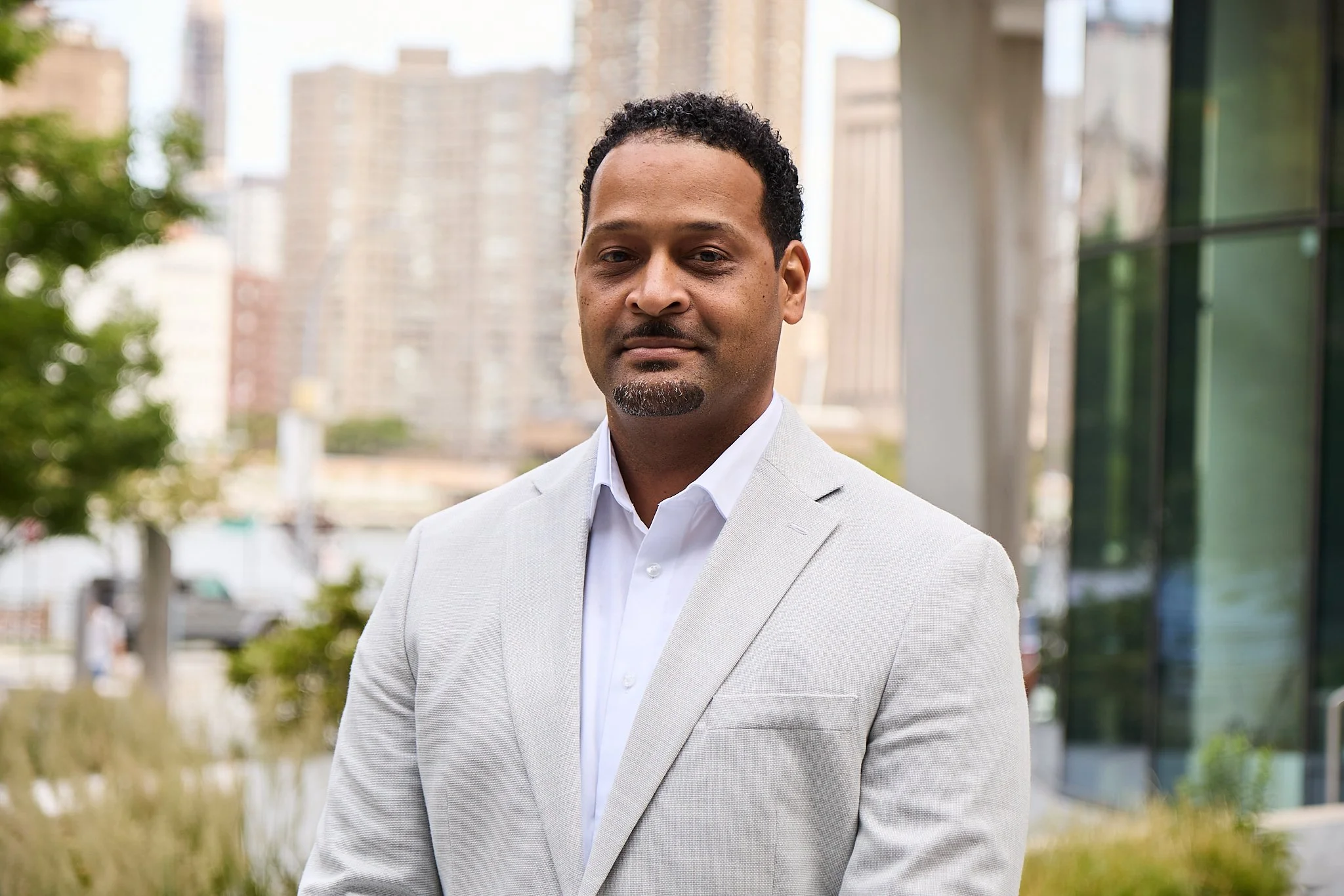 Alphonso Dance Jr. poses outdoors in a light gray blazer