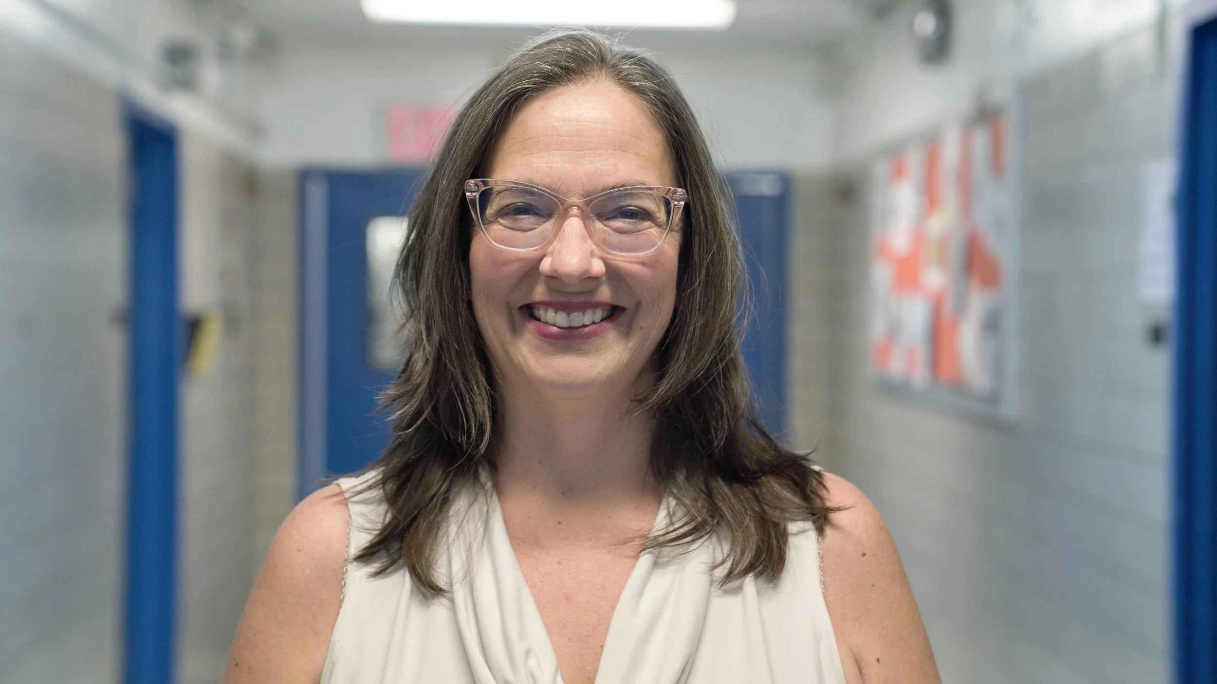 Tracey Scronic smiling in a school hallway