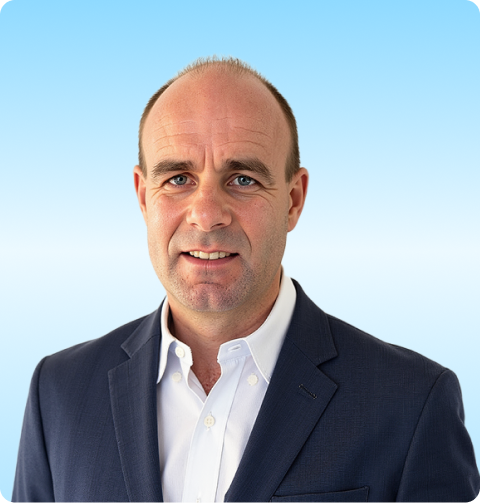 Middle-aged man with short hair wearing a navy blazer and white shirt against a light blue background.