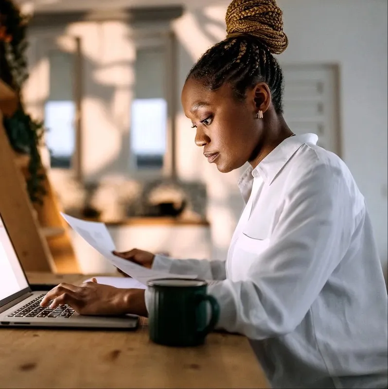 Professional reviewing compliance documentation on a laptop