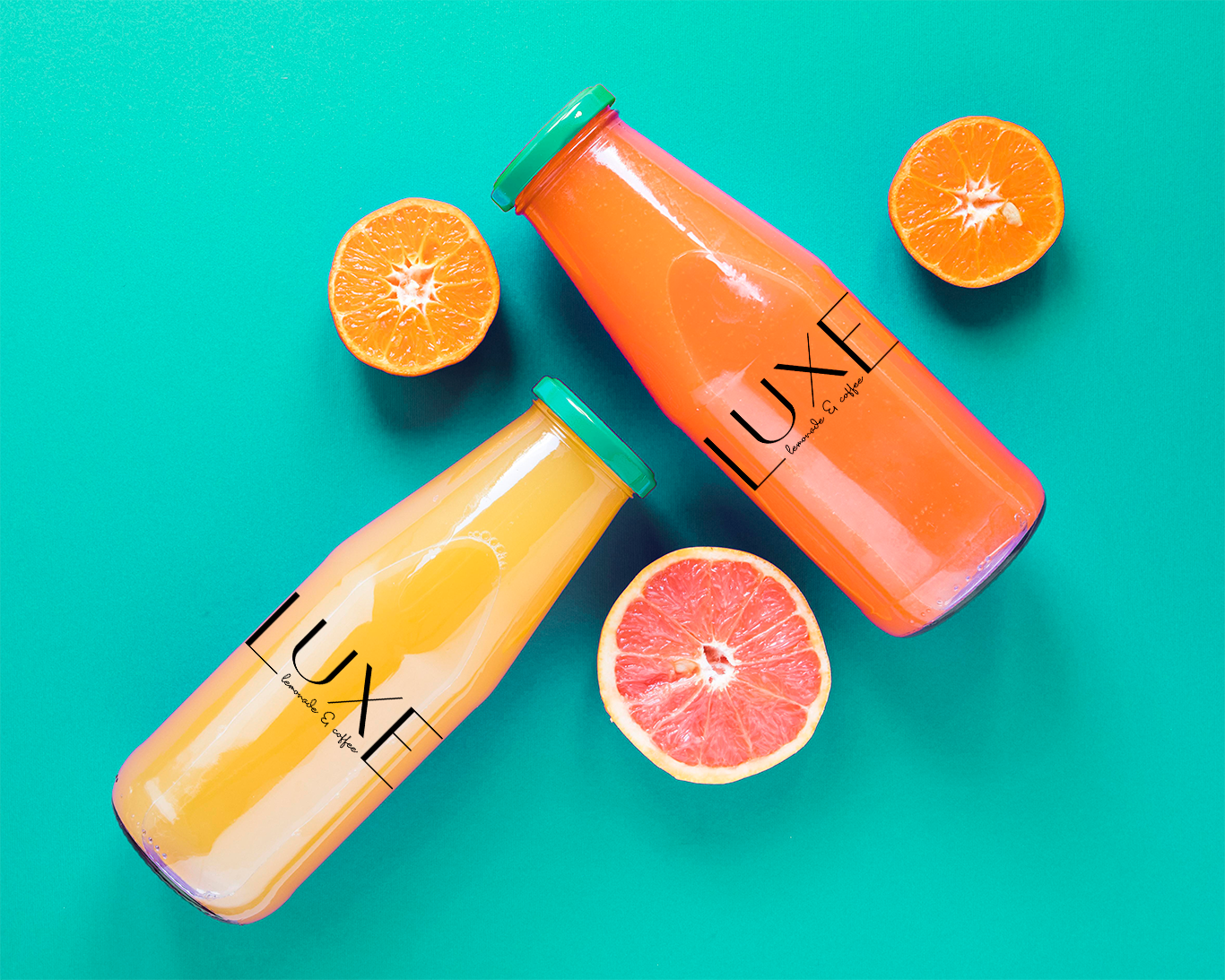 Two glass bottles labeled LUXE with orange and yellow juice surrounded by halved citrus fruits on teal.