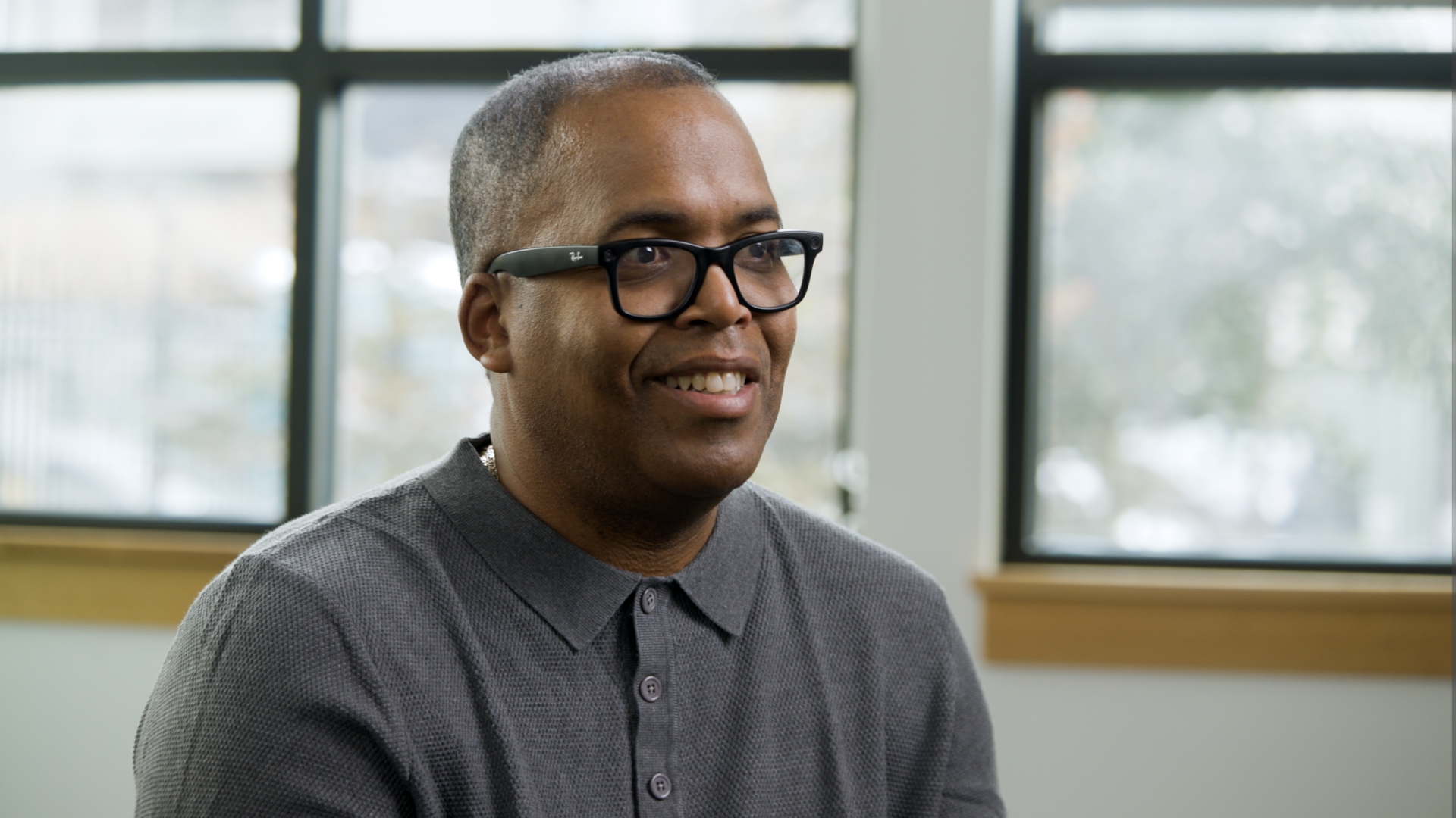 Interview subject smiling during a professionally lit on-camera interview in an office.