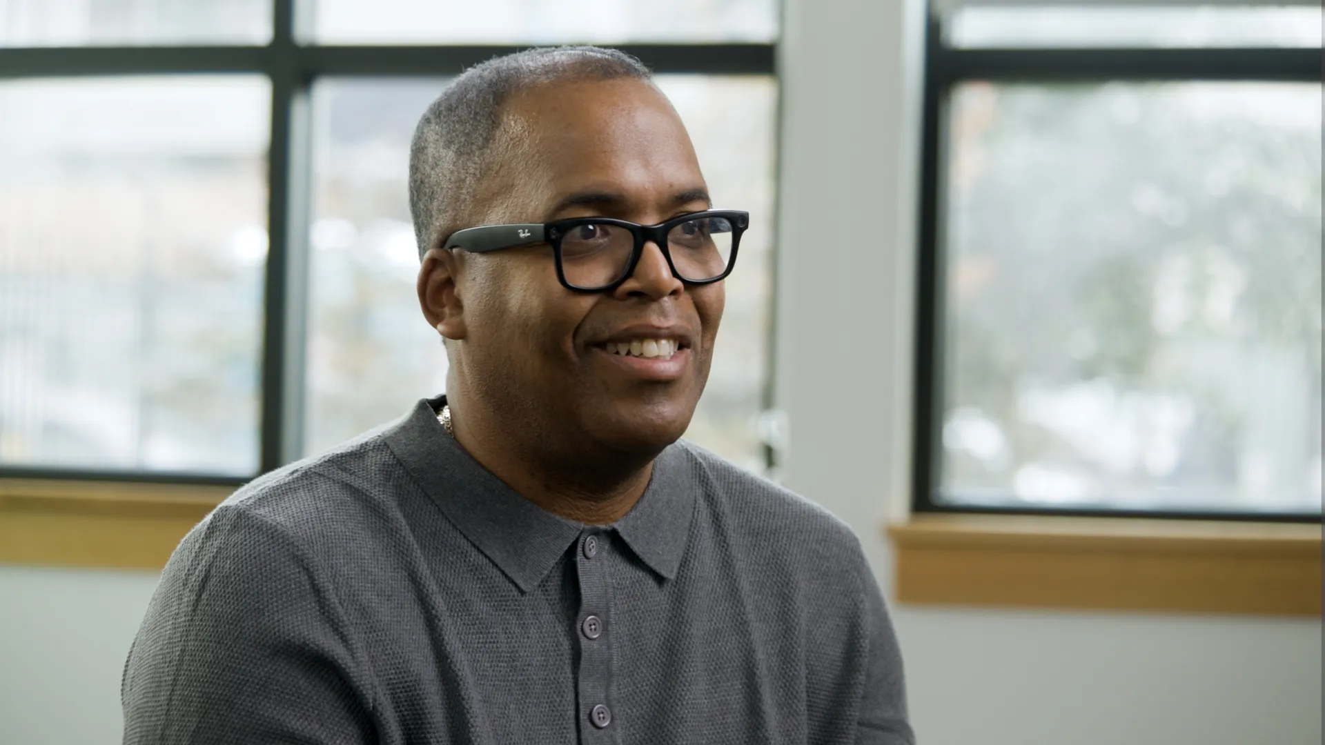 Interview subject smiling during a professionally lit on-camera interview in an office.