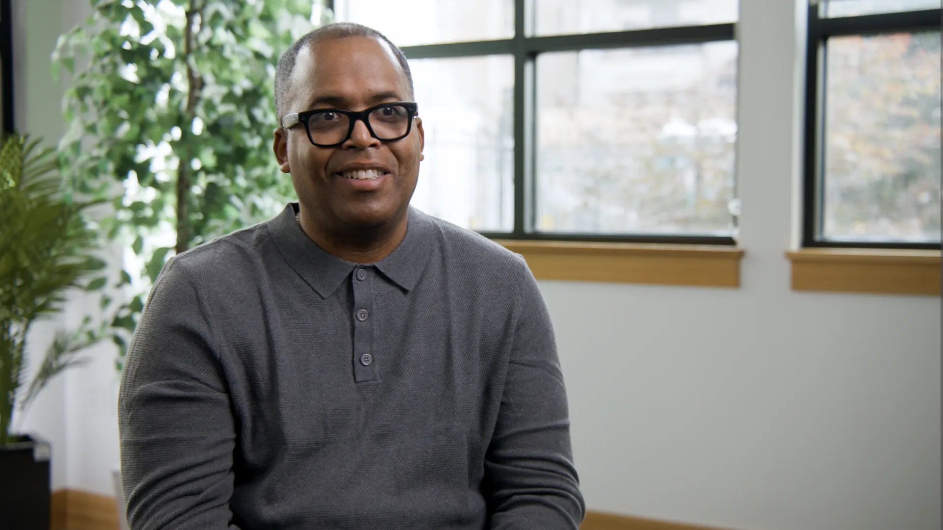 Interview subject speaks on camera for a nonprofit mission video in a bright, professional office