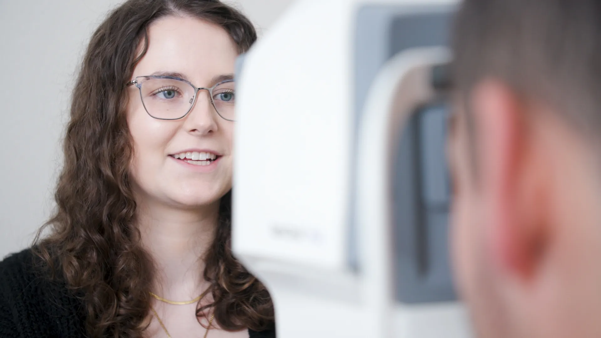 Employee talks to an interviewer during an on-camera business video shoot with soft lighting