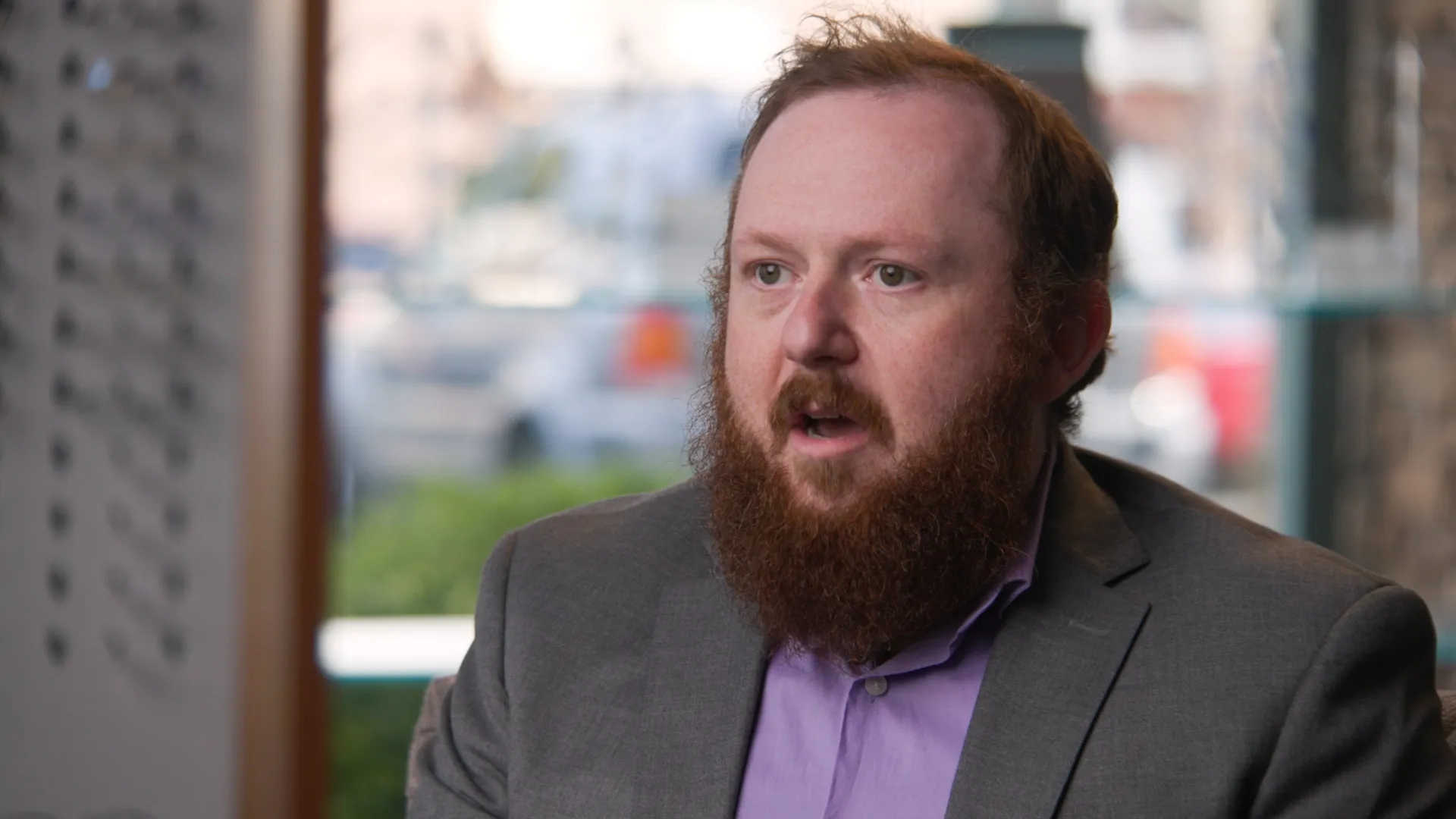 Interview subject talks on camera for a business training or testimonial video with a blurred office background