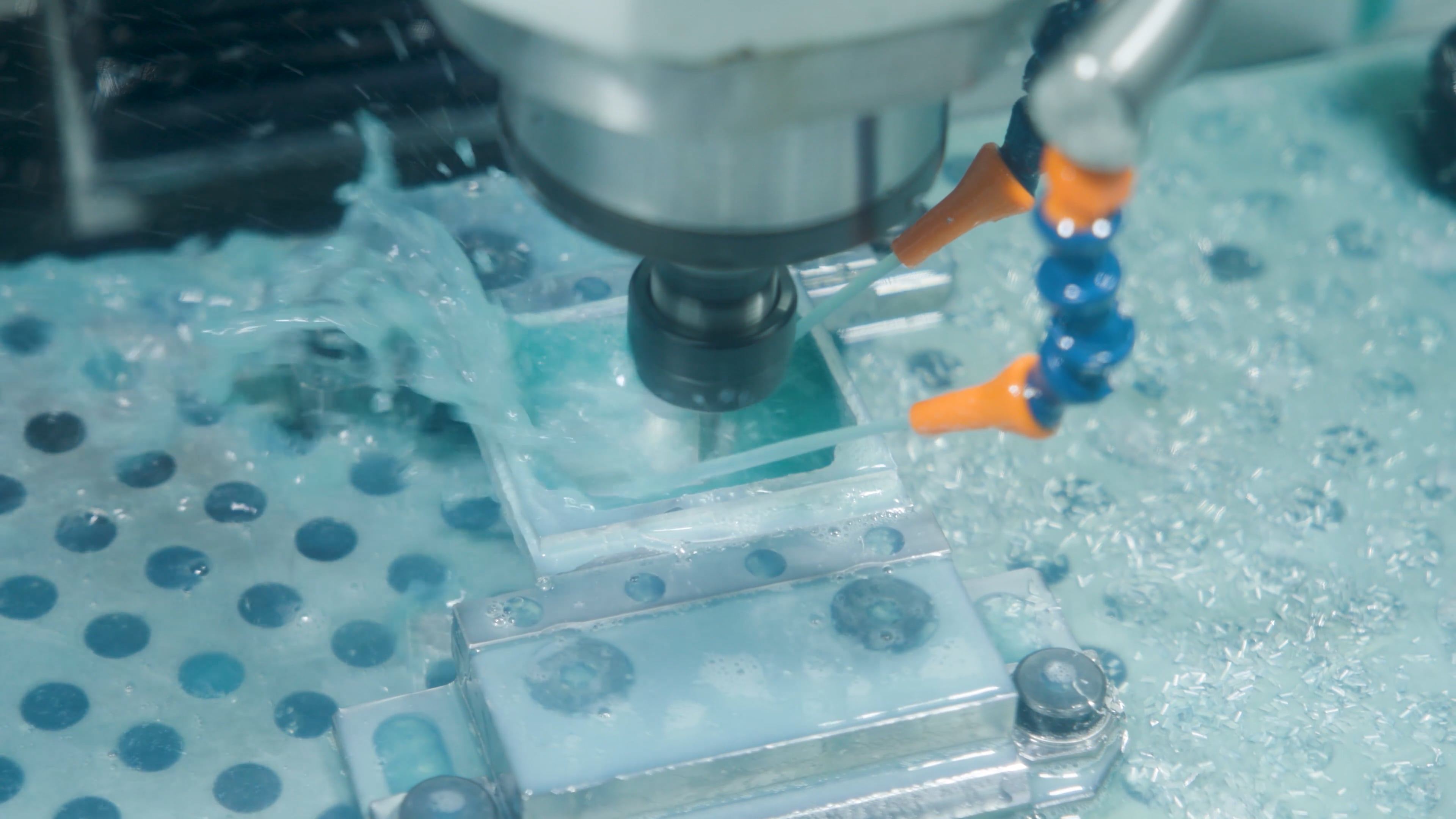 Microscope examining orange and blue biological samples on multi-well laboratory plate