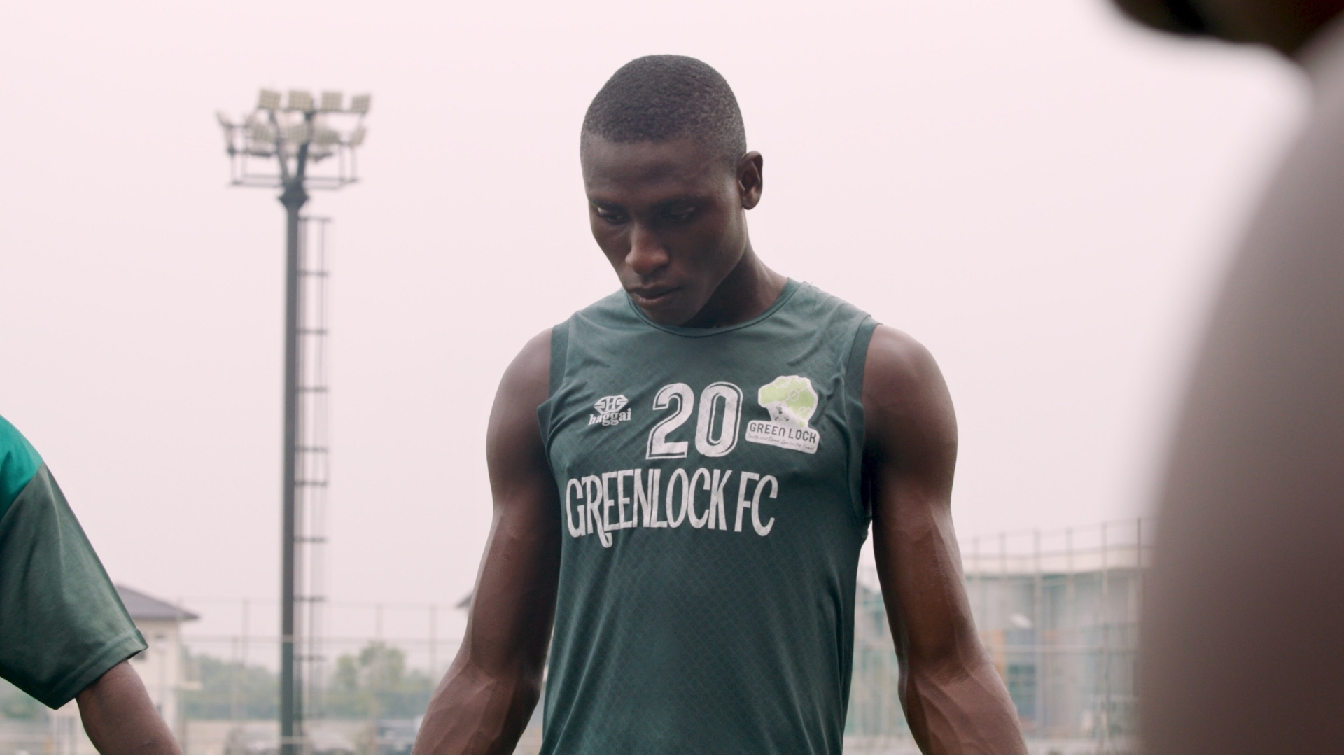 Soccer player wearing Greenlock FC number 20 jersey at outdoor stadium