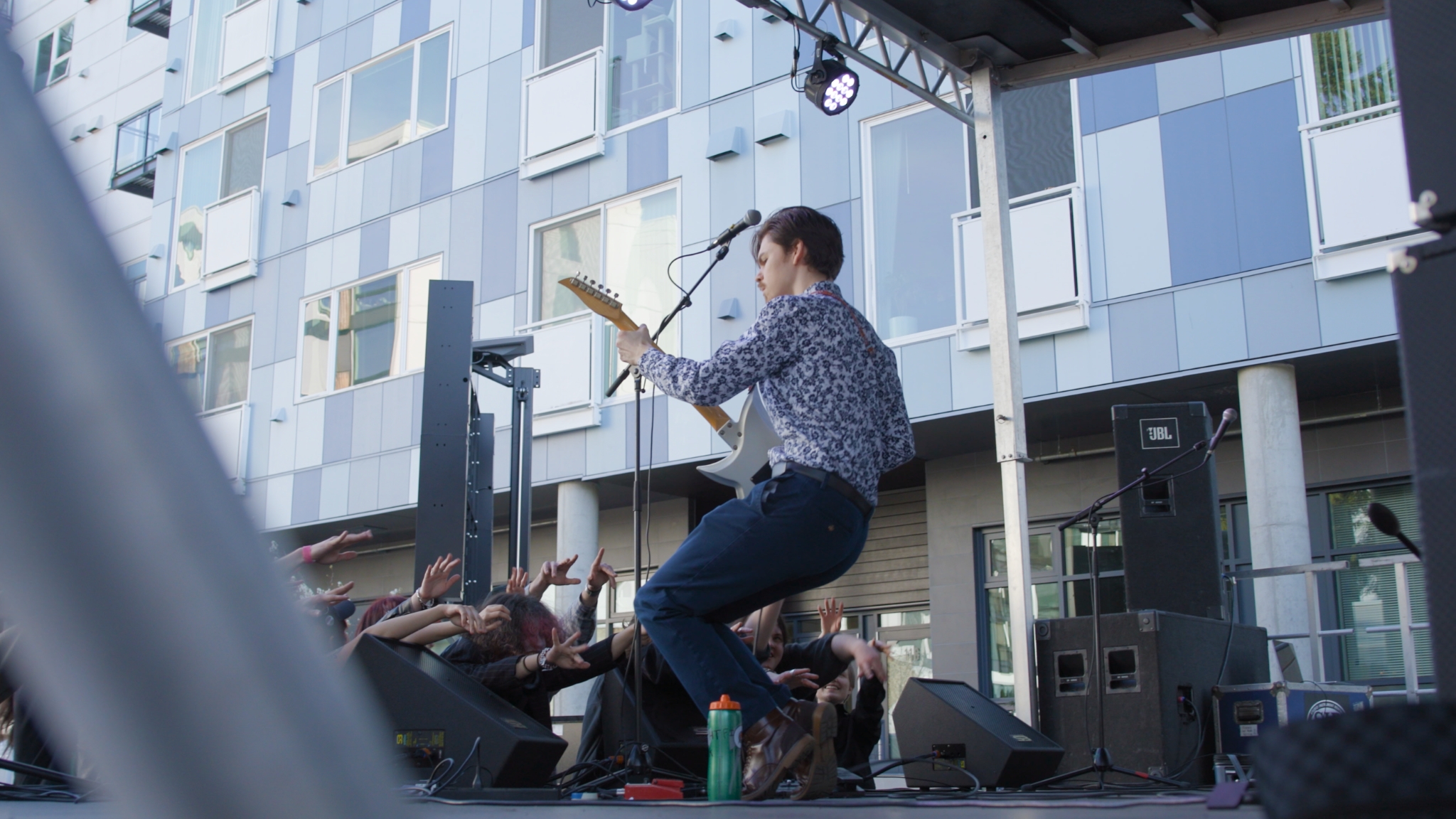Teen musician performs live on an outdoor stage for a crowd at the Old Fire House Teen Center in Redmond.