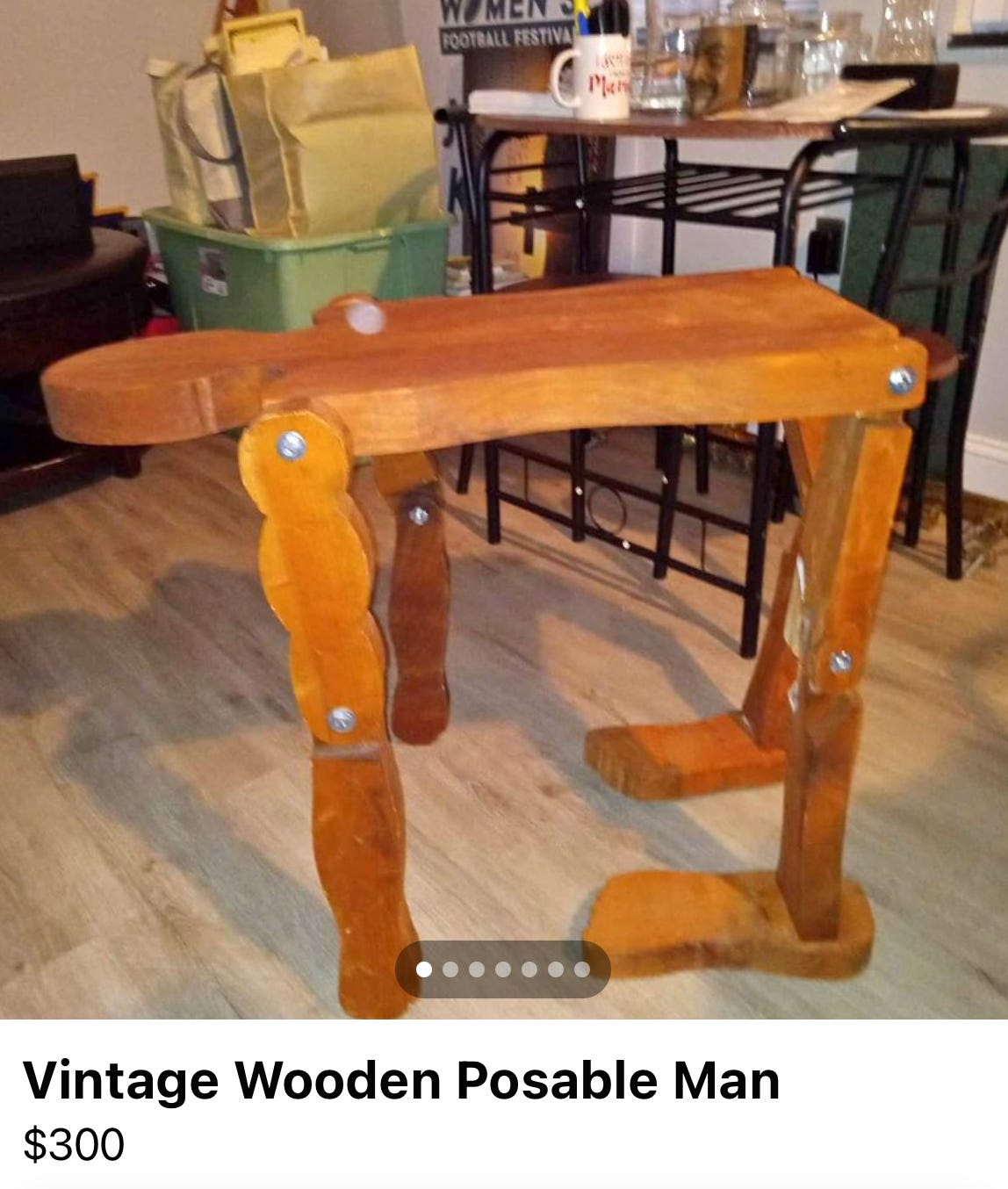 a "vintage wooden posable man" posed in a bent over stance.