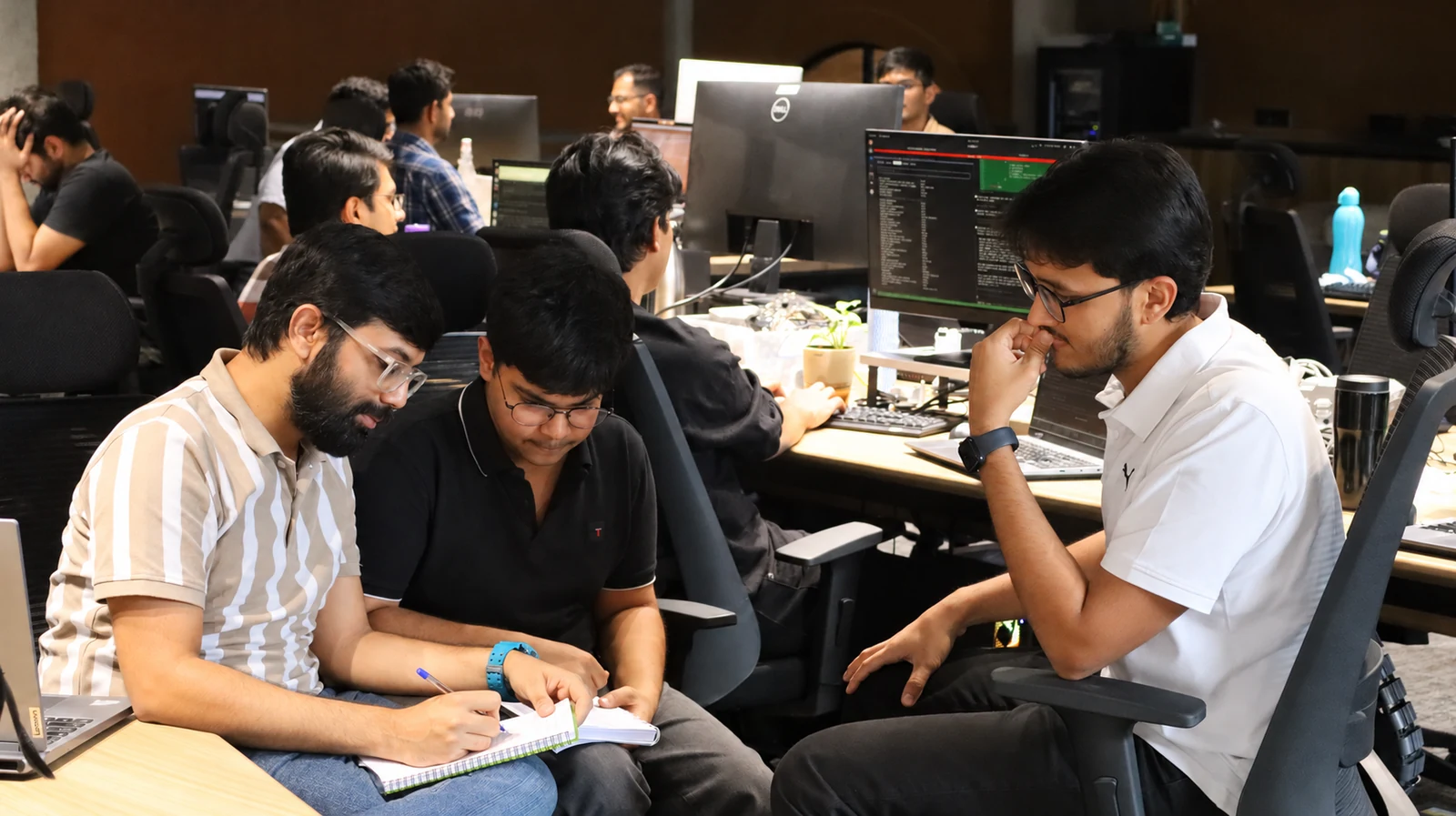 Origin teammates planning together around a notebook