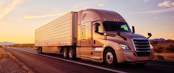 Light gray leather recliner chair with extended footrest in modern living room by a window with curtains.