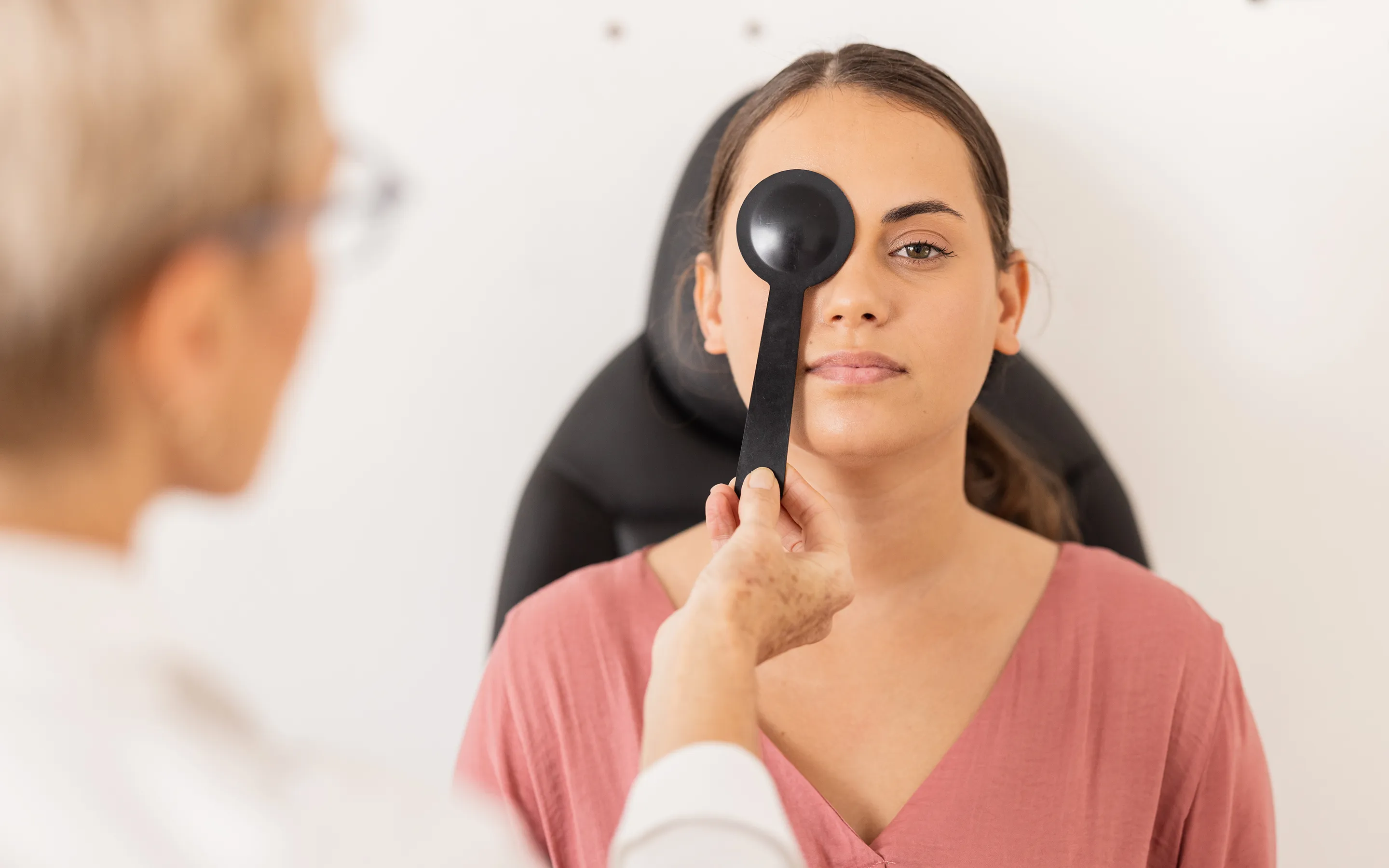 Patient undergoing vision test during thorough eye examination with professional optometrist