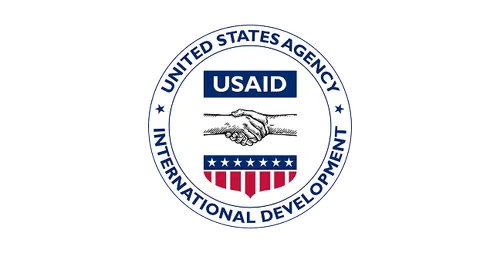 Seal of the United States Agency for International Development (USAID) featuring two hands shaking above a shield with stars and stripes.