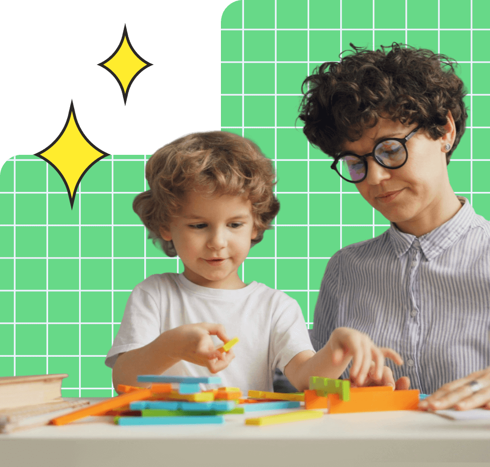 Child playing with colorful blocks at a table while an adult with glasses watches nearby against a green grid background.