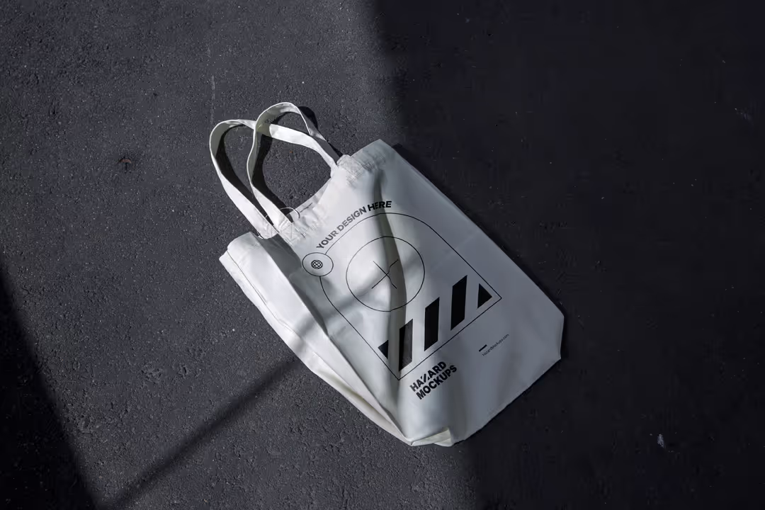 Minimal totebag mockup on dark concrete floor. With realistic shadows and 3D wrapping