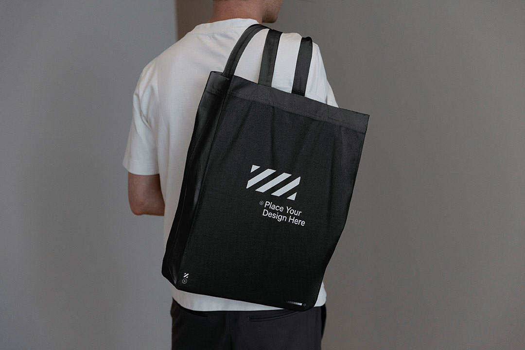 Over shoulder canvas tote bag mockup in minimal setting. With special black-mode for unique dark effect.