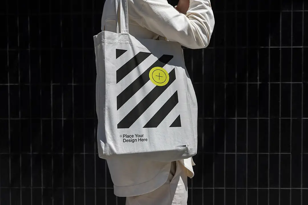 Perfect for apparel and accessory brands, this mockup showcases a model walking with a customizable canvas tote bag, allowing you to change colors and designs. Ideal for capturing an authentic urban vibe, it's great for social media, e-commerce, and marketing presentations!
