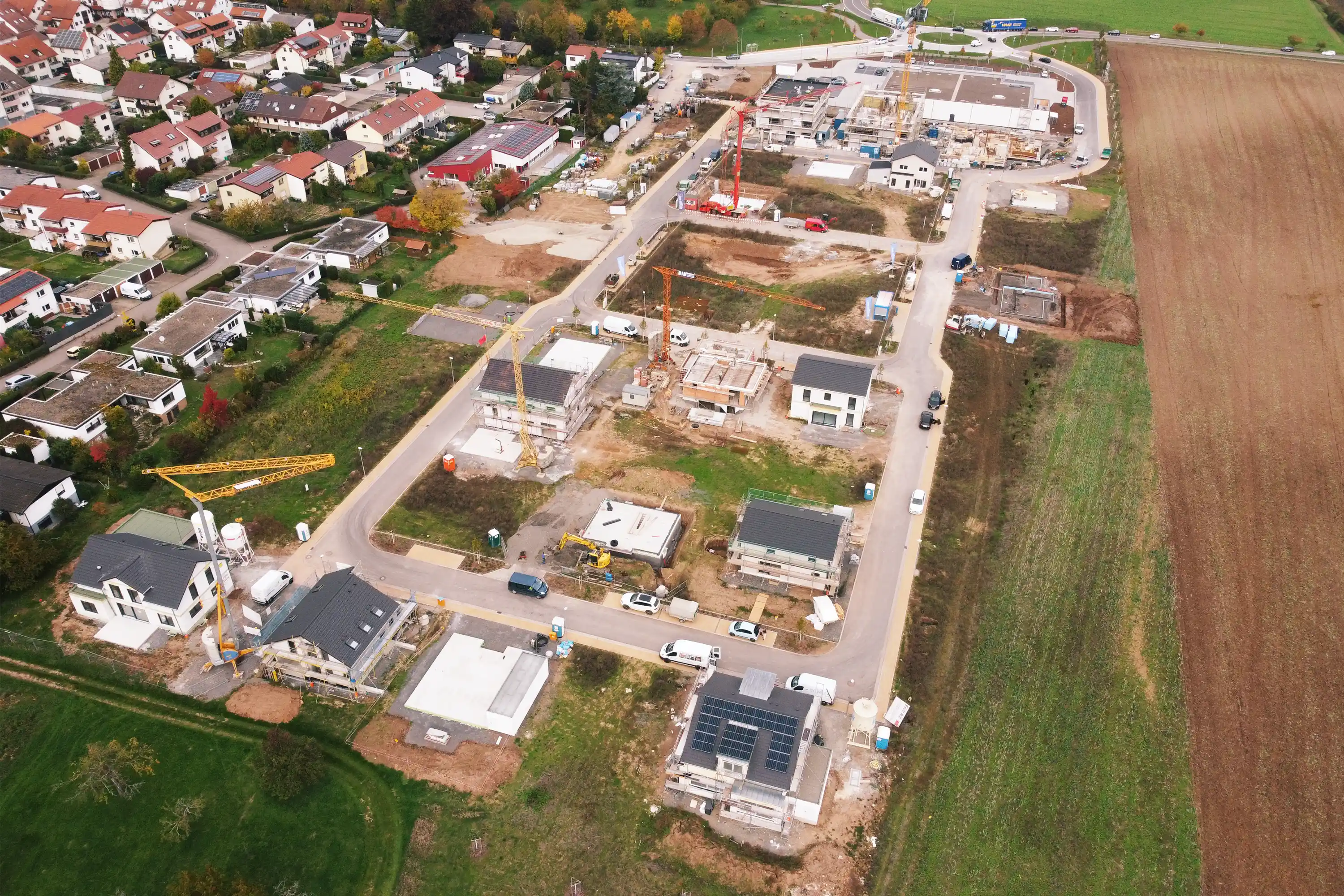 Freudental aus der Luft: Wohngebiet im Bau mit Kränen, Rohbauten und neuen Straßen, angrenzend an Felder.
