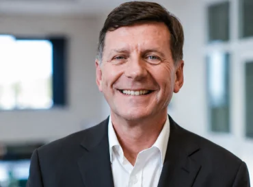 Alan Laffoley in suit jacket and white shirt in an indoor office setting.