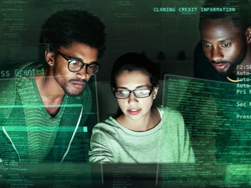 Three people focused on a computer screen with green digital code overlays.