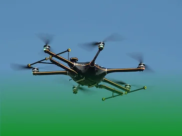 Black drone flying against a clear blue and green gradient background.