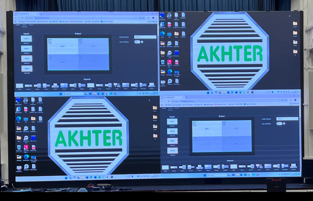 Large LED screen showing four Windows desktops with 'AKHTER' logo and input/output control panels.